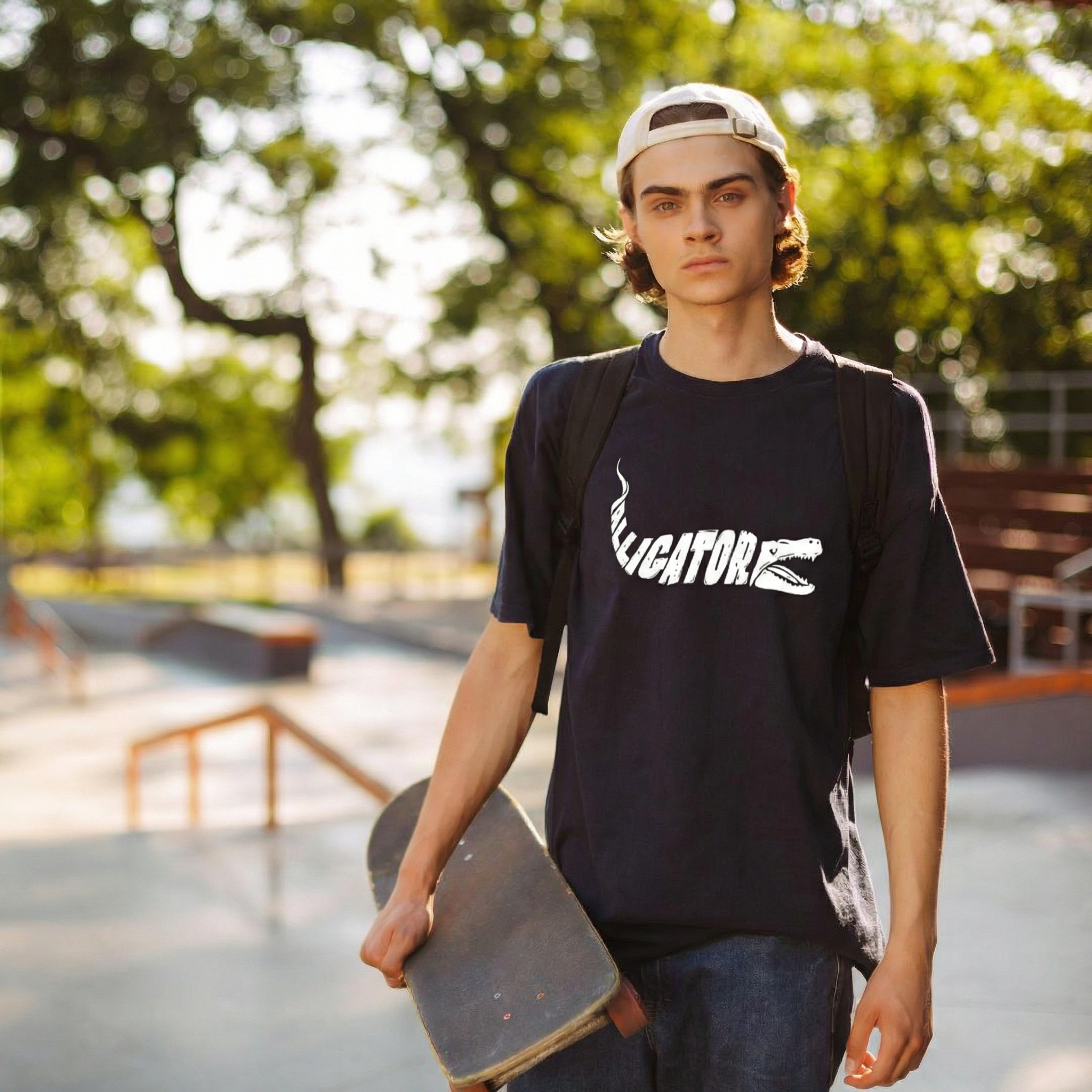 Person holding a skateboard at a skate park with trees in the background